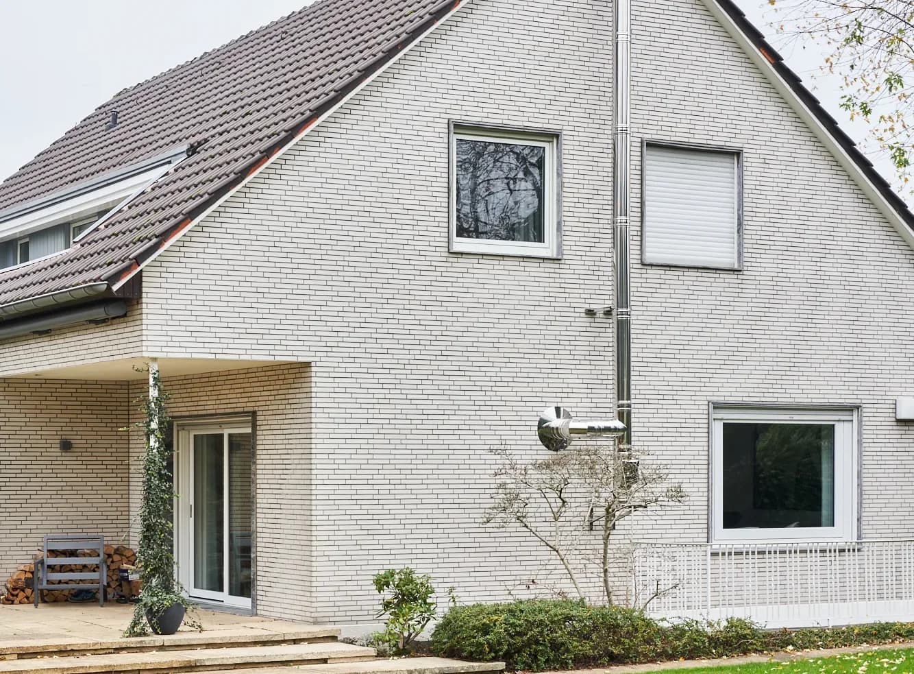 Doppelwandiger Edelstahl-Schornstein an der Giebelseite eines Wohnhauses